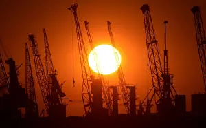 Prints of Cranes of German shipyard Blohm&Voss are silhouetted against the setting sun in Hamburg July 22, 2013. Picture taken July 22 Germany Prints: Cranes of German shipyard Blohm&Voss are silhouetted during sunset in Hamburg