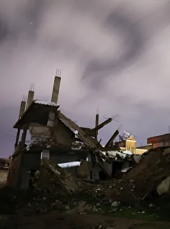 Syria Prints: Damaged houses are pictured at night in the rebel-held area, in the city of Daraa, Syria