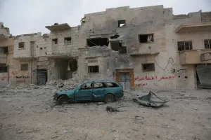 Mideast Prints: A damaged vehicle is seen near buildings in the northern Syrian town of al-Bab