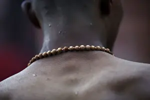 A devotee wearing prayer beads returns after taking a holy bath at the Saali River on