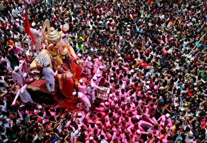 Devotees carry an idol of Hindu god Ganesh during a procession on the last day of