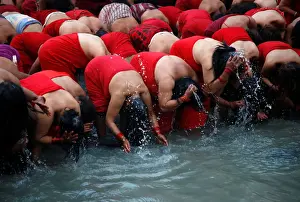 Devotees take a holy bath in the Bagmati River at Pashupatinath Temple during