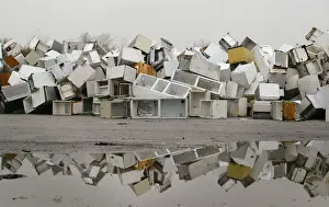 Disused fridges and freezers lie piled up in a storage yard in Manchester