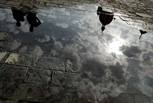 Domes of a hotel are reflected in a puddle of rain water in Mumbai