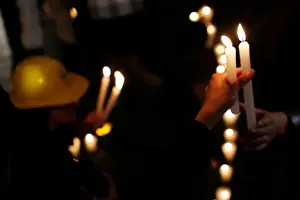 Mexico Prints: Earthquake victim holds a candle to mark the four-month anniversary of the September 19