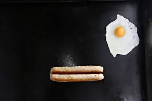 An egg and a sausage fry on a grill in Mays snack van along the A22 near Caterham