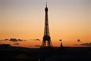 The Eiffel Tower is seen in silhouette at sunset in Paris