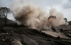 Guatemala Prints: An excavator removes ash from an area affected by the eruption of Fuego volcano in San