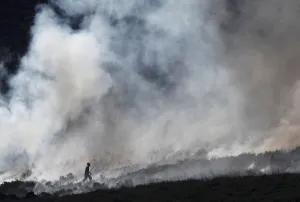 Prints of A firefighter works at fire on a moor above Carrwood, Britain, June 27, 2018. REUTERS/Phil Noble Britain Prints: A firefighter works at fire on a moor above Carrwood