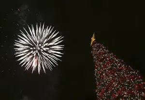 Fireworks light up the sky over a Christmas tree during a lighting ceremony at central