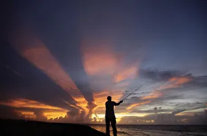 Cuba Prints: A fisherman casts his line as the sun sets on the outskirts of Havana
