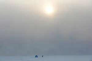 Prints of A fisherman sits on an ice-covered bay of the Yenisei River, with the air temperature at about minus 35 degrees Celsius (minus 31 degrees Fahrenheit), in Krasnoyarsk, Russia, January 17, 2017 Russia Prints: A fisherman sits on an ice-covered bay of the Yenisei River in Krasnoyarsk