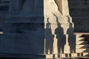 Flag-bearers of war veteran associations cast their shadows during a ceremony
