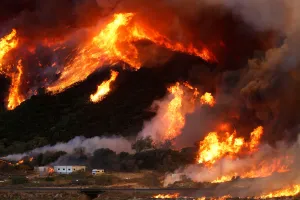 California Prints: Flames whipped by strong winds burn though a hillside before destroying camper vans