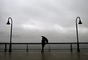 Images Dated 2014 January: Fog shrouds the skyline of New York as a woman stands next to the Hudson River on a pier