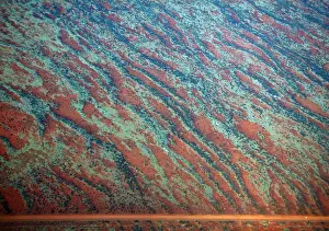 Landscapes Prints: A general view of a road next to sand dunes covered in vegetation in the Pilbara region