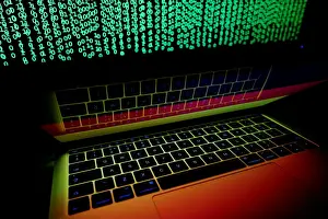 Cyber Prints: German flag is seen on the laptop screen in front of a computer screen on which cyber