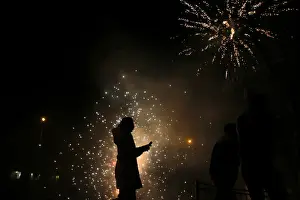A girls walks as residents set off fireworks as part of Chinese New Year celebrations