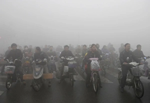 Prints of People ride electric bikes amid heavy fog on a street in Huai an, Jiangsu province, November 8, 2009 China Prints: GM1E5B8191U01