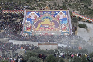 Prints of Tibetan Buddhists and tourists view a huge Tangka, a religious silk embroidery or painting unique to Tibet, during the Shoton Festival at Drepung Monastery on the outskirts of Lhasa China Prints: GM1E68B0S9M01