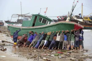 Prints of Fishermen try to push a stranded boat back to the sea at Tanmen port in Qionghai, Hainan province, October 8, 2010 China Prints: GM1E6A817X501