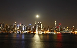 <b class=qtipBold><figcaption>GM1E94Q0SP201</figcaption></b><br>A full moon rises over the skyline of New York City above 42nd Street (C), as seen across the Hudson River in Weehawken, New Jersey April 25, 2013. REUTERS/Gary Hershorn (UNITED STATES - Tags: CITYSCAPE ENVIRONMENT) - RTXZ0FB GM1E94Q0SP201