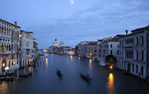 Gondoliers row in an empty Grand Canal in Venice