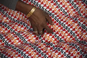 A hand of a migrant worker from India is pictured as he makes a blanket from recycled