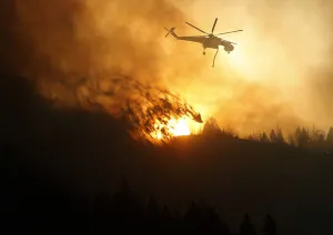 Wildfire Prints: A helicopter air tanker dumps water as the sun sets at the Beaver Creek wildfire outside