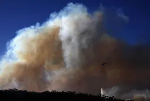 Prints of A helicopter drops water on a bushfire approaching homes near the Blue Mountains suburb of Blackheath, located around 70 km (43 miles) west of Sydney, October 23, 2013 Australia Prints: A helicopter drops water on a bushfire approaching homes near the Blue Mountains suburb