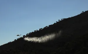 Spain Prints: A helicopter drops water over a wildfire in the neighborhood of Entrerrios in Mijas