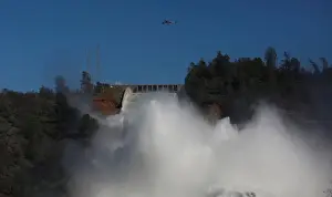 California Prints: Helicopters carry rocks as water is released from the Lake Oroville Dam after an