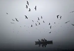 Hindu devotee travel in a boat to visit a temple located in the waters of the river