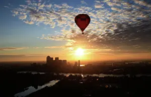 A hot air balloon rises into the early morning sky in front of the Canary Wharf financial