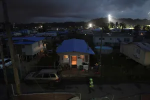 A house is lit up with the help of a generator next to houses in the dark after Hurricane A house is lit up with the help of a generator next to houses in the dark after Hurricane