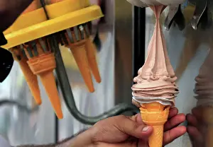 An ice cream vendor fills a cone with chocolate ice cream in Peshawar