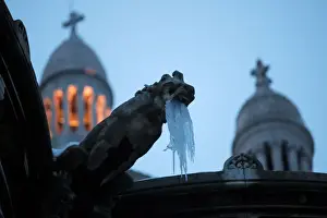 France Prints: Icicles hang from a gargoyle on the Sacre Coeur basilica at the Butte Montmartre in Paris