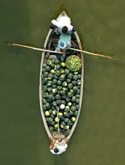 Indian farmers carry watermelons on a boat across the river Ganges in Allahabad