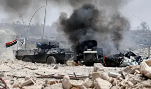 Mideast Prints: An Iraqi military armoured fighting vehicle (AFV) drives past a burning Iraqi military