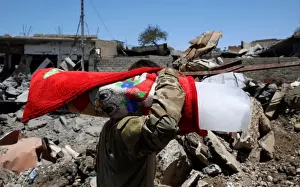An Iraqi soldier carries a block of ice for his comrades at their positions in Mosul s