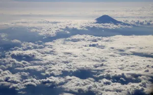 Japan Prints: Japans Mount Fuji, surrounded by cloud, is seen from an airplane