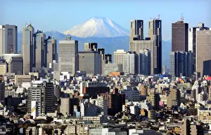 Japans Mt Fuji, covered with snow, is seen through Shinjuku skyscrapers in Tokyo