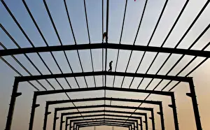 A labourer walks on a steel frame at a construction site in Nanjing