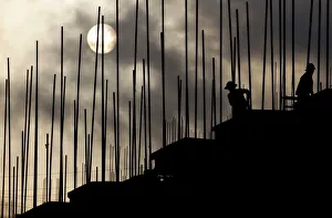 Labourers work during sunrise at a construction site of a residential complex in Puer Labourers work during sunrise at a construction site of a residential complex in Puer