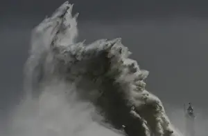 Large waves hit the lighthouse and harbour at high tide at Newhaven in Sussex