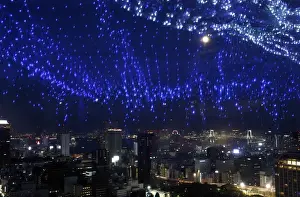 A light display of the Milky Way is reflected on a window as skyscrapers and the Tokyo