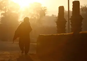 Nepal Prints: Light illuminates a devotee as she returns after offering prayers during the Swasthani