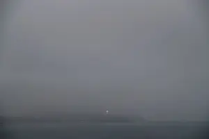 The lighted cross of Chorrillos is seen from a cliff overlooking the Pacific ocean