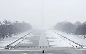 Weather Prints: A lone tourist walks on the National Mall near the Lincoln Memorial during a snow storm