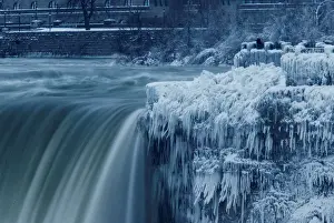 Weather Prints: A lone visitor takes a picture near the brink of the ice covered Horseshoe Falls in